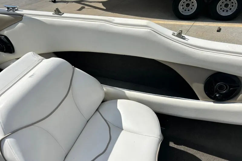 Slide: The Image of Interior of a 1999 Bayliner 1954 Capri boat with white seating and speaker. - 16