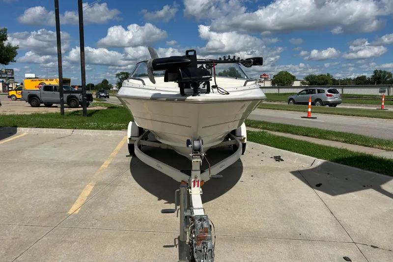 Slide: The Image of 1999 Bayliner 1954 Capri boat on trailer in parking lot under cloudy sky. - 7