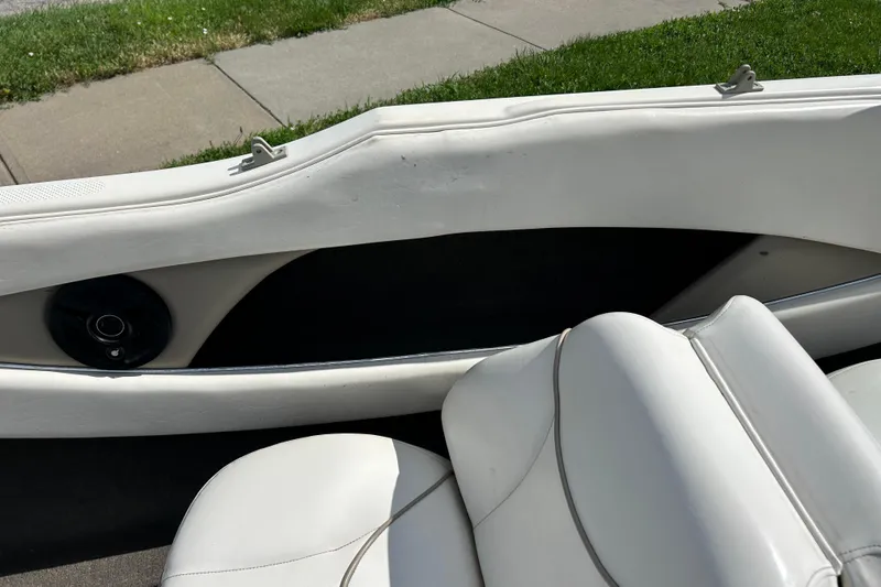Slide: The Image of Interior of a 1999 Bayliner 1954 Capri boat with white seating and speaker detail. - 14