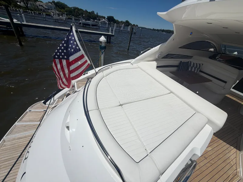 Slide: The Image of The image shows the stern of a 2008 Sunseeker Portofino 53 with a large sunbed and an American flag. - 13