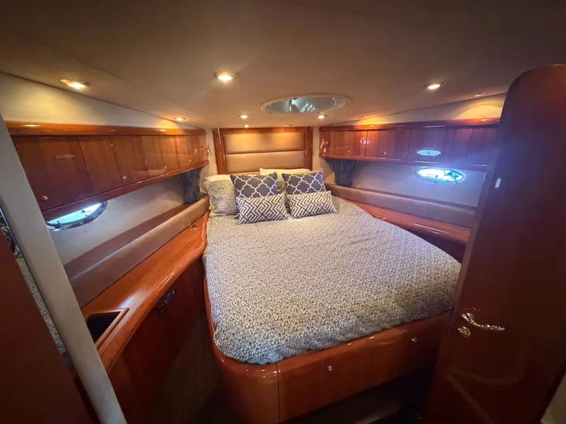 Slide: The Image of Luxurious cabin with a large bed, wooden furnishings, and porthole windows. - 23
