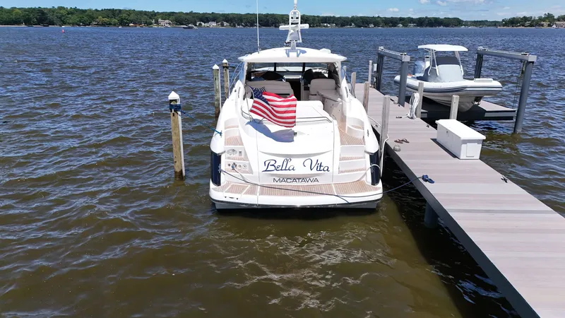 Slide: The Image of A 2008 Sunseeker Portofino 53 docked at a pier. An American flag waves at the stern. - 3