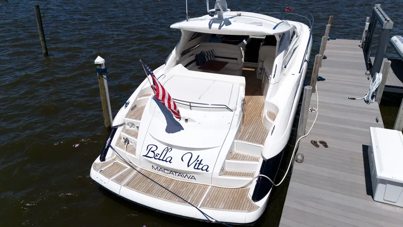 Slide: The Image of A luxurious 2008 Sunseeker Portofino 53 yacht docked, featuring an American flag. - 4