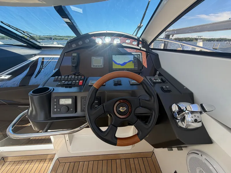Slide: The Image of The cockpit of a Sunseeker Portofino 53 with modern instruments and a wooden steering wheel. - 5