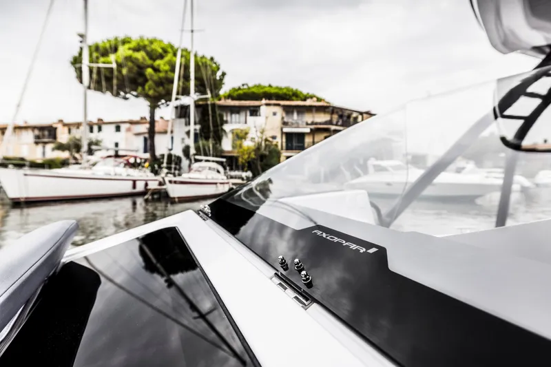 Slide: The Image of Close-up of an Axopar 25 Cross Top boat in a harbor with sailboats in the background. - 18