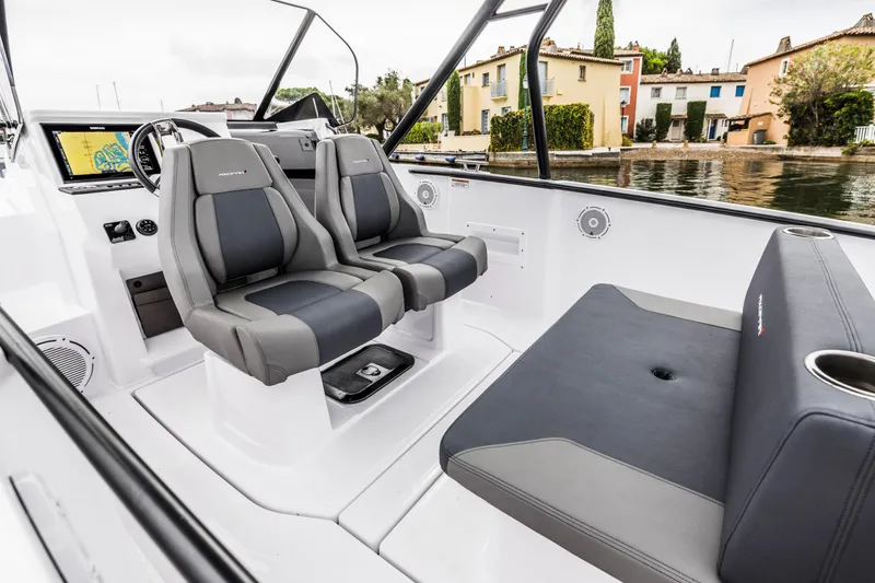 Slide: The Image of Axopar 25 Cross Top 2023: Modern seating and helm, situated by the water. - 20