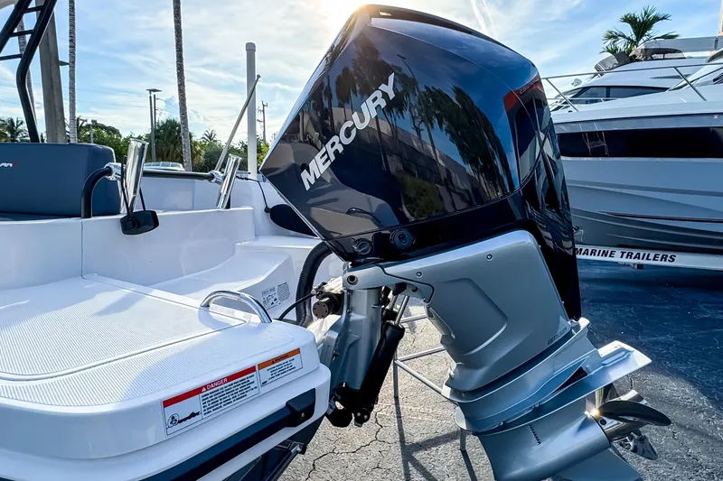 Slide: The Image of 2023 Axopar 25 Cross Top boat with Mercury outboard motor in marina setting. - 4