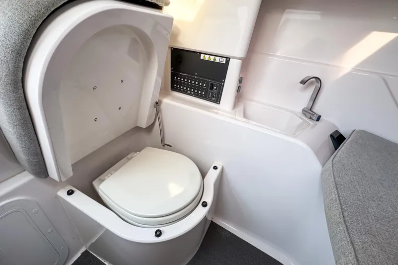 Slide: The Image of 2023 Axopar 25 Cross Top boat interior with compact toilet and sink. - 15