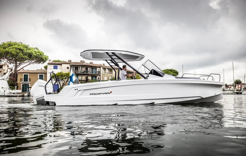 Slide: The Image of A modern motorboat floating on calm water near a picturesque coastal town. - 4