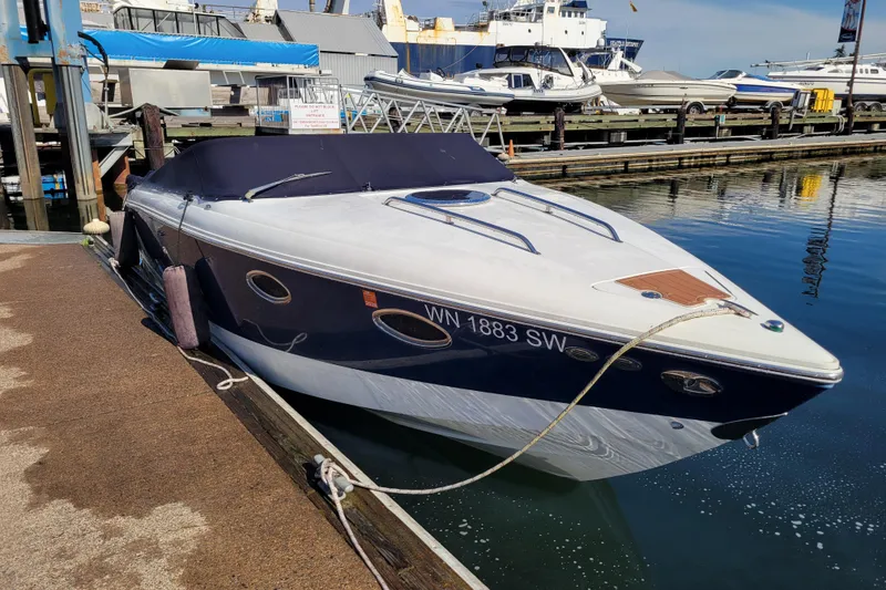 Slide: The Image of 2005 Cobalt 255 boat docked at marina, covered and secured with ropes. - 21