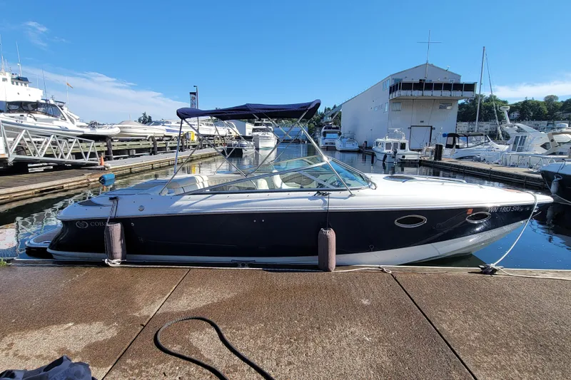 Slide: The Image of 2005 Cobalt 255 boat docked at marina under clear blue sky. - 2