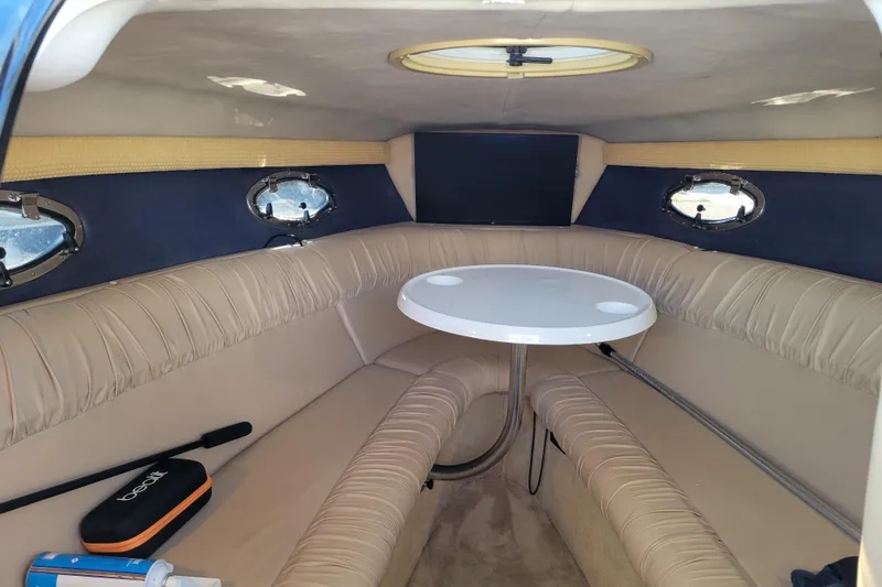 Slide: The Image of Interior of a 2005 Cobalt 255 boat with beige seating and a round table. - 14