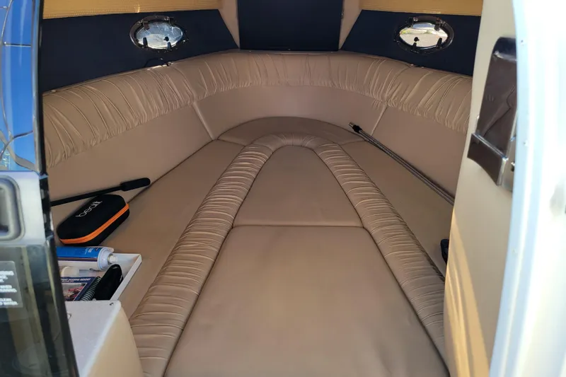 Slide: The Image of Interior cabin of a 2005 Cobalt 255 boat with beige seating and portholes. - 18