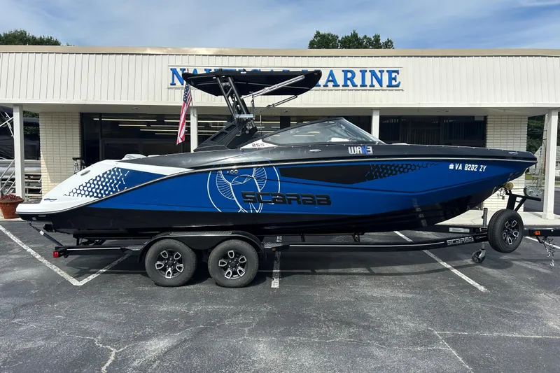 The Image of 2023 Scarab 255 Wake ID boat on trailer outside marine dealership. - 0