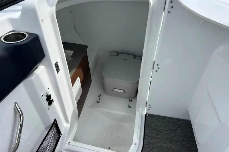 Slide: The Image of 2023 Scarab 255 Wake ID boat interior with compact marine toilet and sink. - 12