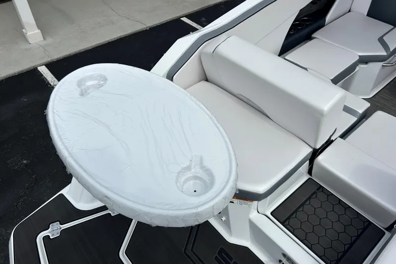 Slide: The Image of 2023 Scarab 255 Wake ID boat interior with white seating and oval table. - 14