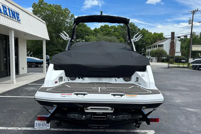 Slide: The Image of 2023 Scarab 255 Wake ID boat with cover, parked outside a marine dealership. - 31