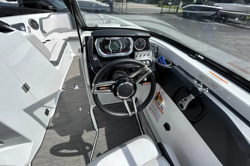 Slide: The Image of 2023 Scarab 255 Wake ID boat cockpit with steering wheel and dashboard controls. - 9