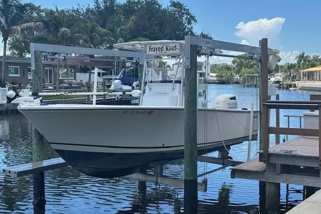 The Image of 2001 SeaCraft SC 23 Classic boat docked on a lift in a scenic marina. - 0