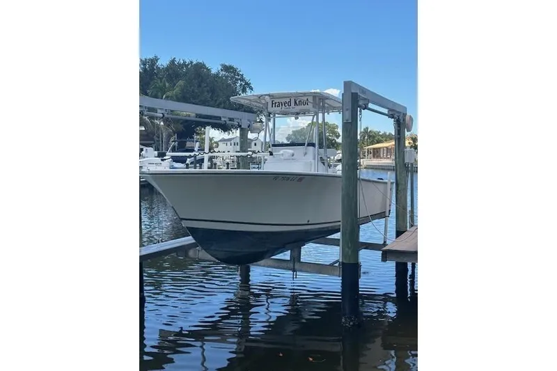 Slide: The Image of 2001 SeaCraft SC 23 Classic boat on lift, docked by waterfront homes. - 2