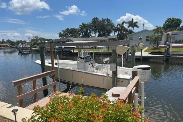 Slide: The Image of 2001 SeaCraft SC 23 Classic boat docked in a sunny residential canal setting. - 5