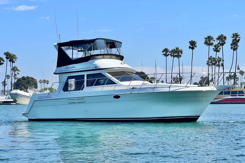 The Image of 1994 Navigator 4300 yacht cruising on clear blue water with palm trees in the background. - 0
