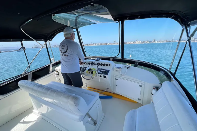 Slide: The Image of Person steering a 1994 Navigator 4300 yacht on calm blue waters. - 13