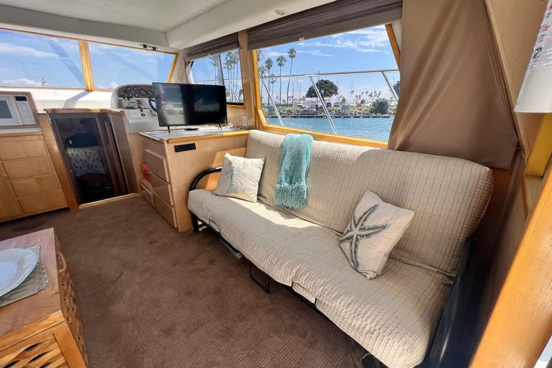 Slide: The Image of Interior of 1994 Navigator 4300 yacht with cozy seating and scenic window view. - 17