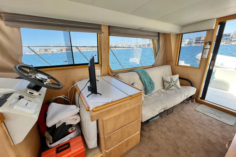 Slide: The Image of Interior of 1994 Navigator 4300 yacht with helm, sofa, and waterfront view. - 18