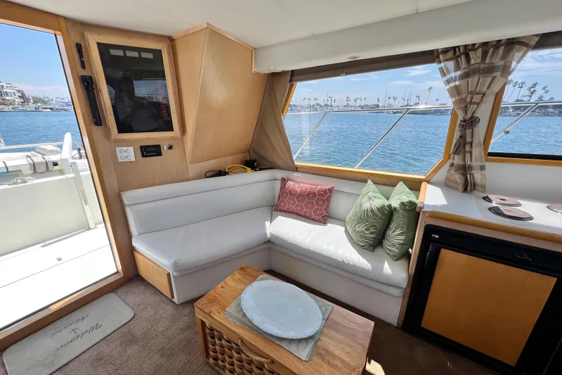 Slide: The Image of Cozy interior of 1994 Navigator 4300 yacht with waterfront view, featuring white seating and decorative pillows. - 20