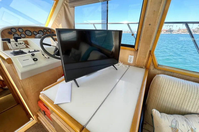 Slide: The Image of Interior of a 1994 Navigator 4300 yacht with steering wheel and TV, overlooking the ocean. - 23
