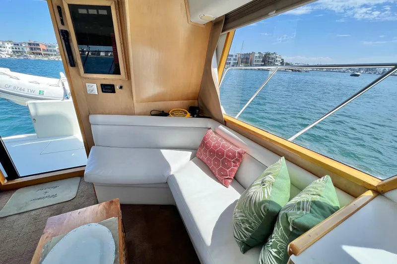 Slide: The Image of Interior of 1994 Navigator 4300 yacht with white seating, colorful cushions, and ocean view. - 25