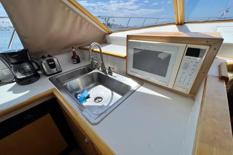 Slide: The Image of 1994 Navigator 4300 yacht kitchen with sink, microwave, coffee maker, and toaster. - 27