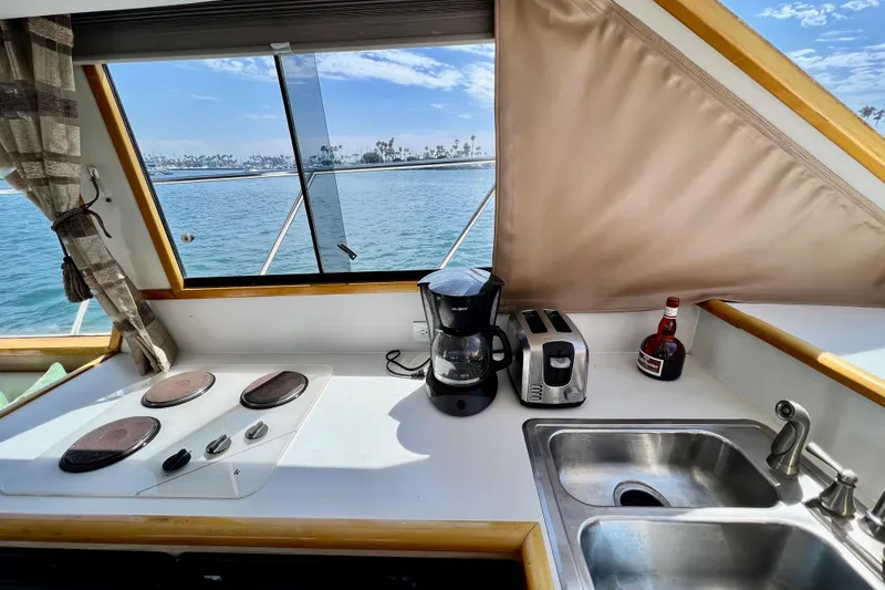 Slide: The Image of Kitchen area on a 1994 Navigator 4300 yacht with ocean view, featuring appliances and sink. - 28