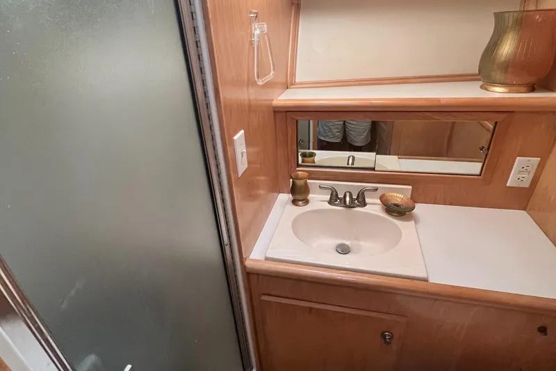 Slide: The Image of Bathroom vanity in 1994 Navigator 4300 yacht with sink, mirror, and decorative items. - 31