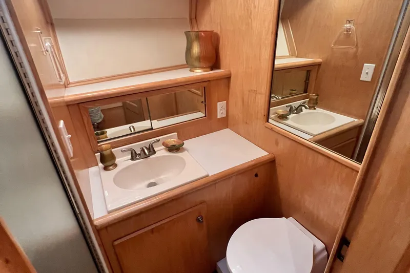 Slide: The Image of Navigator 4300 1994 bathroom with wooden cabinetry, sink, mirror, and toilet. - 32