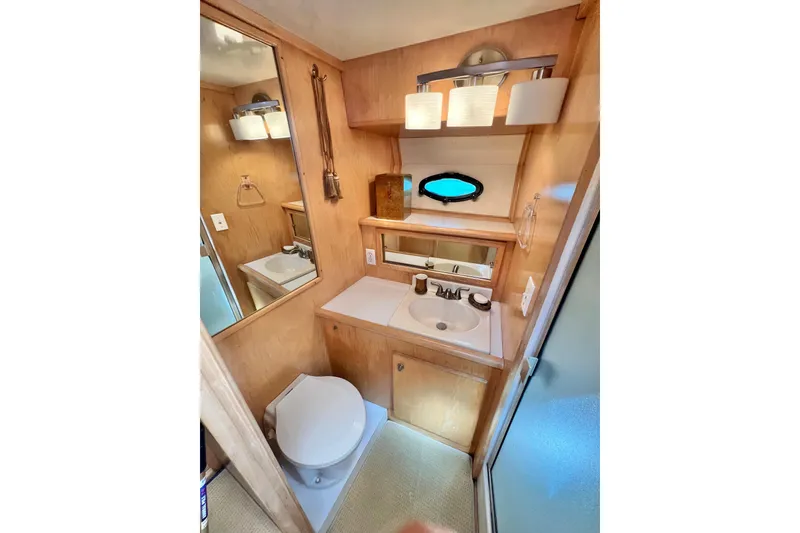 Slide: The Image of 1994 Navigator 4300 yacht bathroom with sink, toilet, mirror, and porthole window. - 34