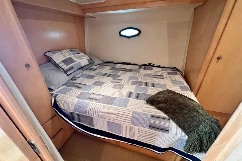 Slide: The Image of Cozy bedroom in 1994 Navigator 4300 yacht with quilted bedding and small porthole. - 37