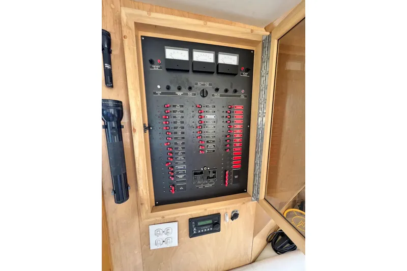 Slide: The Image of Electrical control panel on a 1994 Navigator 4300 boat, featuring switches and meters. - 39