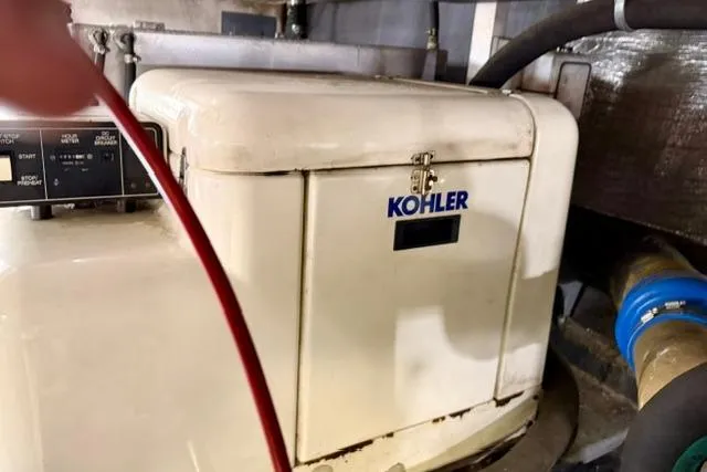 Slide: The Image of Kohler generator in a 1994 Navigator 4300 engine room, featuring control panel and hoses. - 47