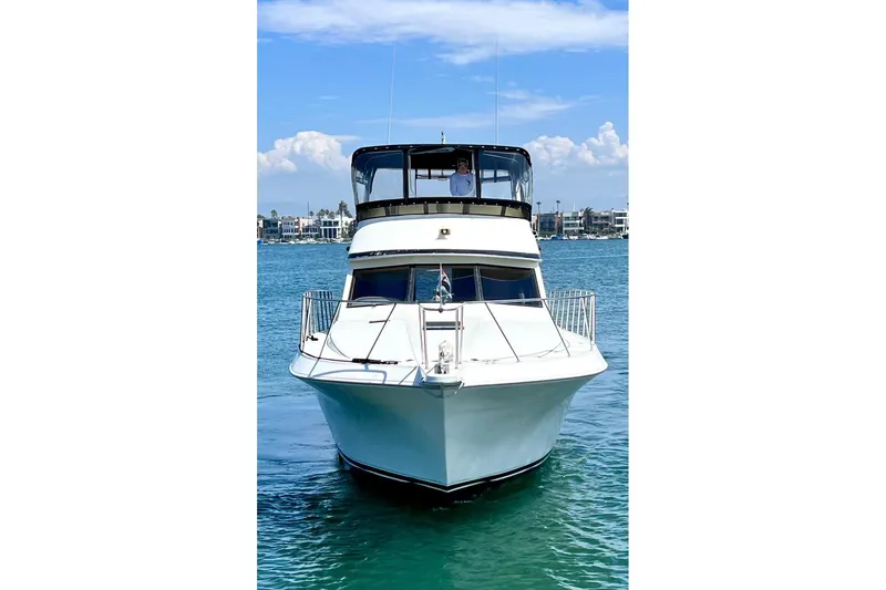 Slide: The Image of Front view of a 1994 Navigator 4300 yacht on calm blue water. - 5