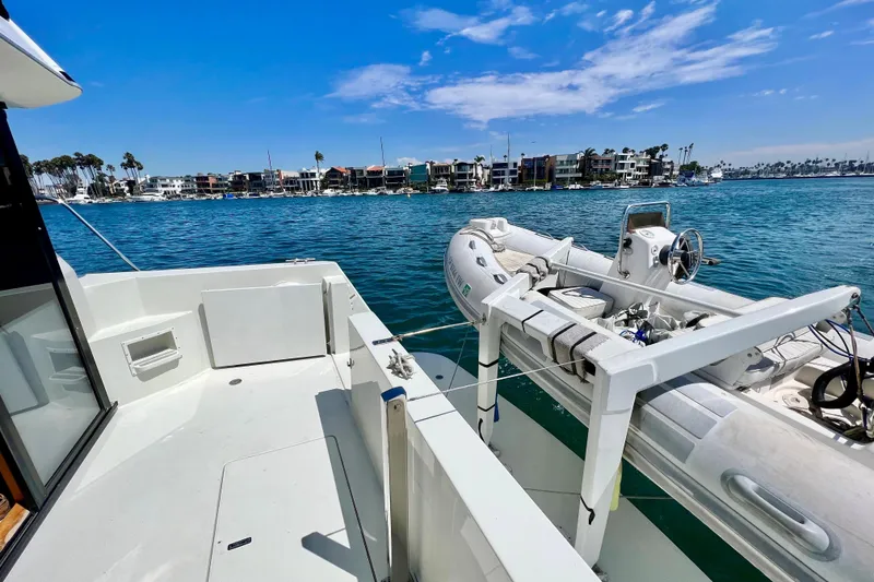 Slide: The Image of Navigator 4300 yacht deck with dinghy, overlooking waterfront homes and clear blue sky. - 9