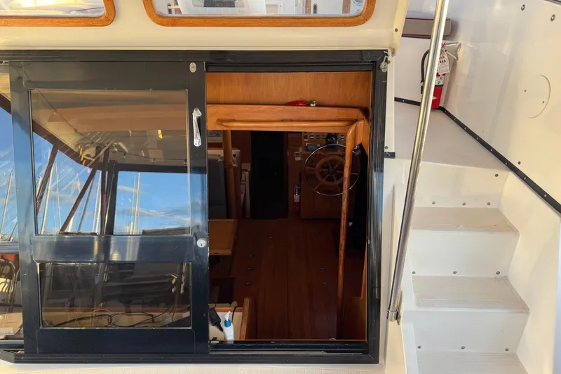 Slide: The Image of Interior view of a 1987 President 37 yacht, showcasing wooden helm and sliding door. - 10