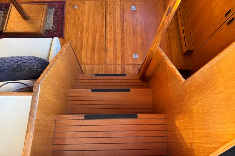 Slide: The Image of Wooden interior stairs on a 1987 President 37 yacht, featuring sleek design and warm tones. - 12