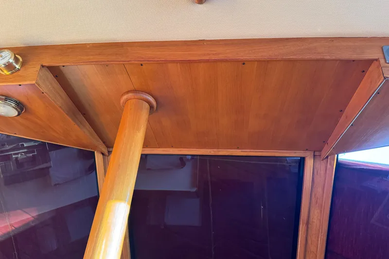 Slide: The Image of Interior view of a 1987 President 37 boat, showcasing wooden ceiling and support beam. - 16