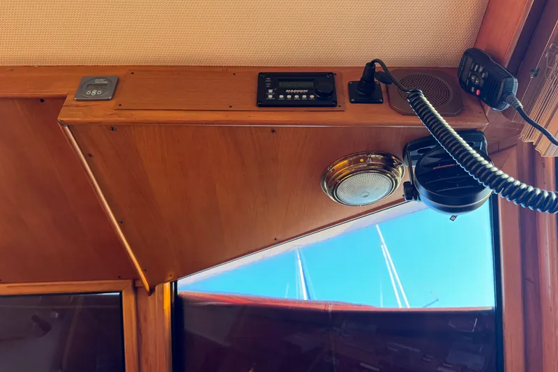 Slide: The Image of Interior view of a 1987 President 37 boat, featuring wooden paneling and communication equipment. - 18