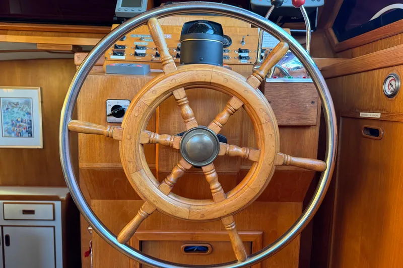 Slide: The Image of Wooden ship wheel on a 1987 President 37 yacht, surrounded by navigation controls. - 21