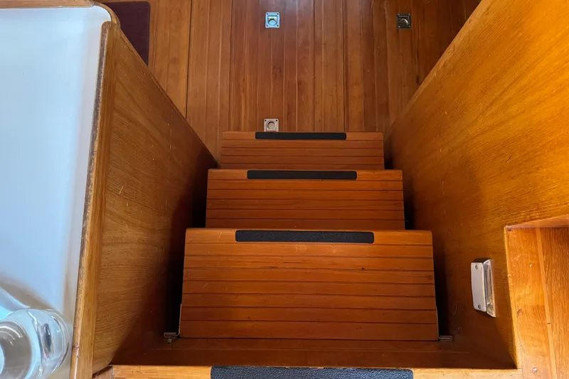 Slide: The Image of Wooden stairs inside a 1987 President 37 yacht, featuring sleek design and warm tones. - 25