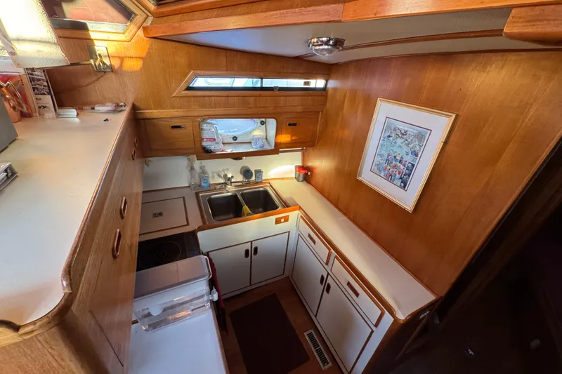 Slide: The Image of Cozy 1987 President 37 yacht kitchen with wood cabinetry and dual sinks. - 28