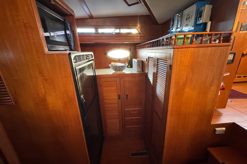 Slide: The Image of Cozy wooden interior of a 1987 President 37 yacht kitchen with appliances and storage. - 29